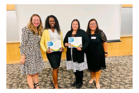 Photo for Clinical Research Equity Scholars Carmine Johnson and Michaella Collins, with two community members, receiving certificates from their participation in the program