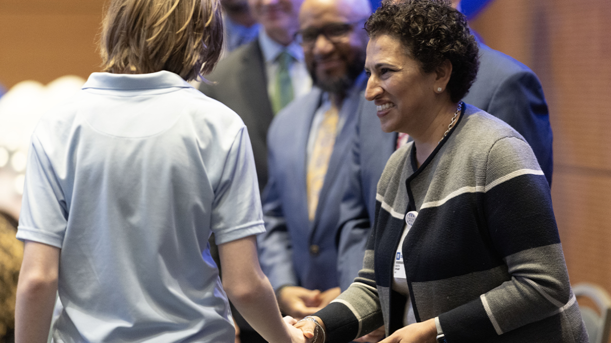 Geeta Swamy, MD, shaking the hand of an incoming freshman