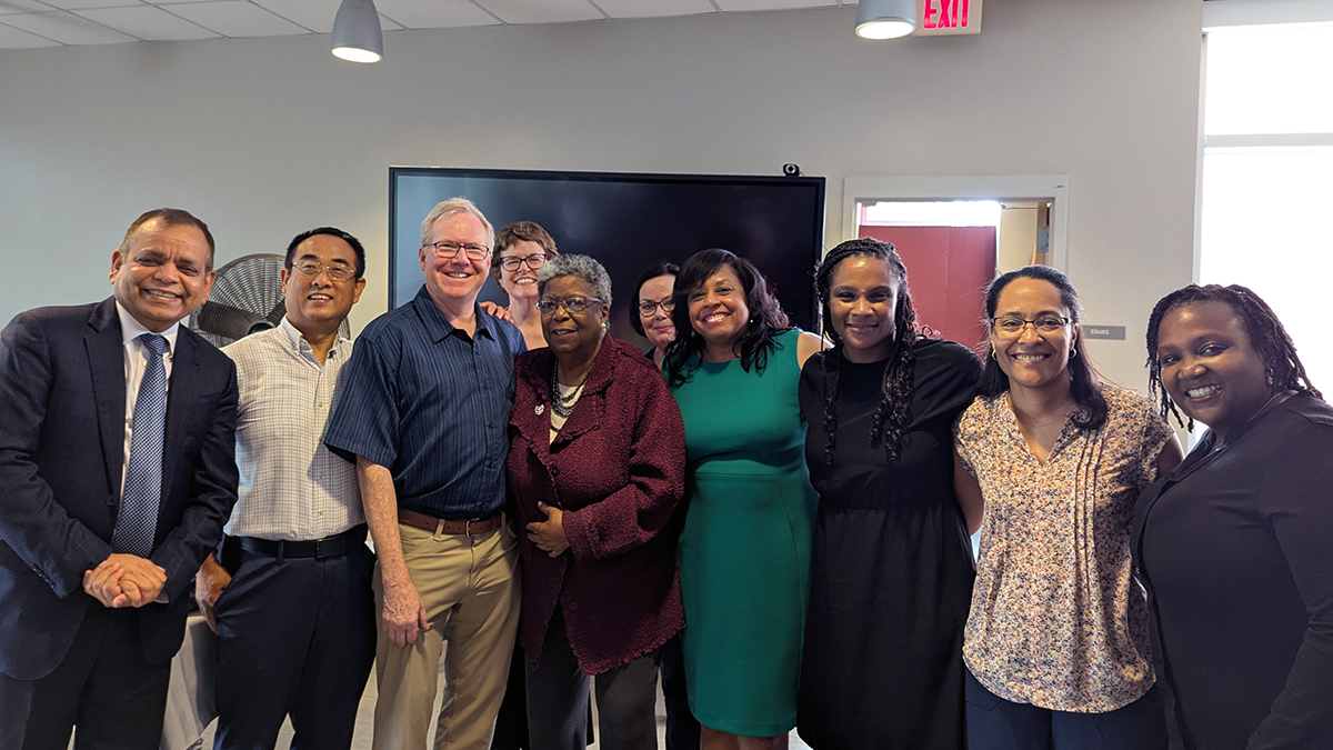 Group photo of Faye Calhoun, PhD surrounded by her colleagues.