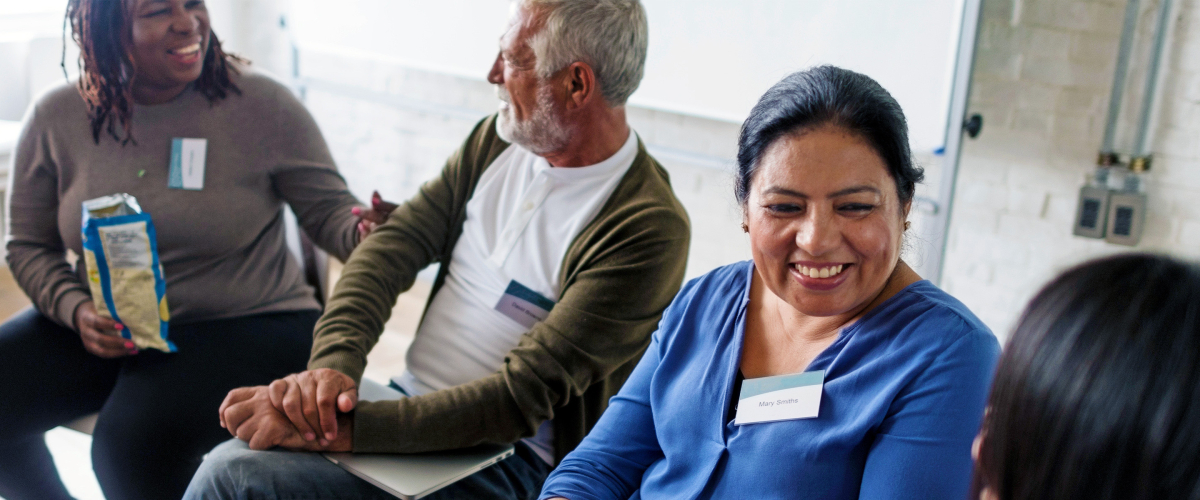 Diverse group of seated adults conversing.