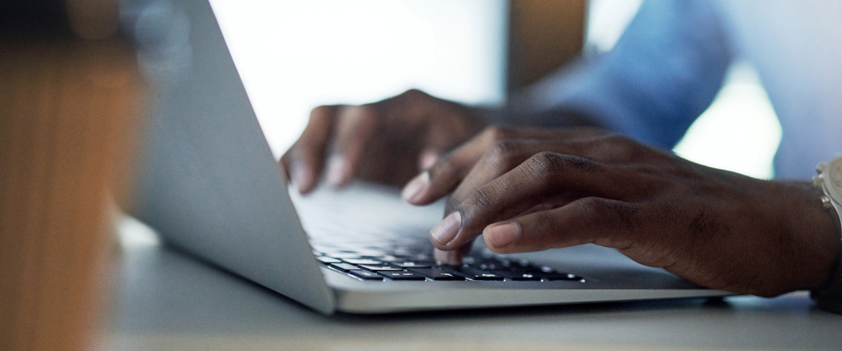 Close shot of hands typing on a laptop.