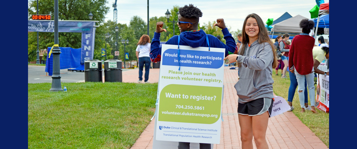Image of young people with recruitment sign at Kannapolis event.