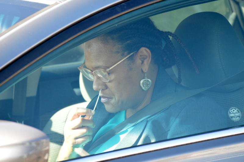 A participant completes a nasal swab test during a drive-through event, part of a study launched in response to the COVID-19 pandemic.