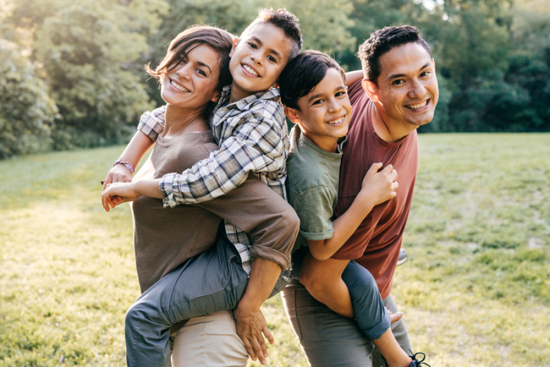 Happy, young family posing outdoors.
